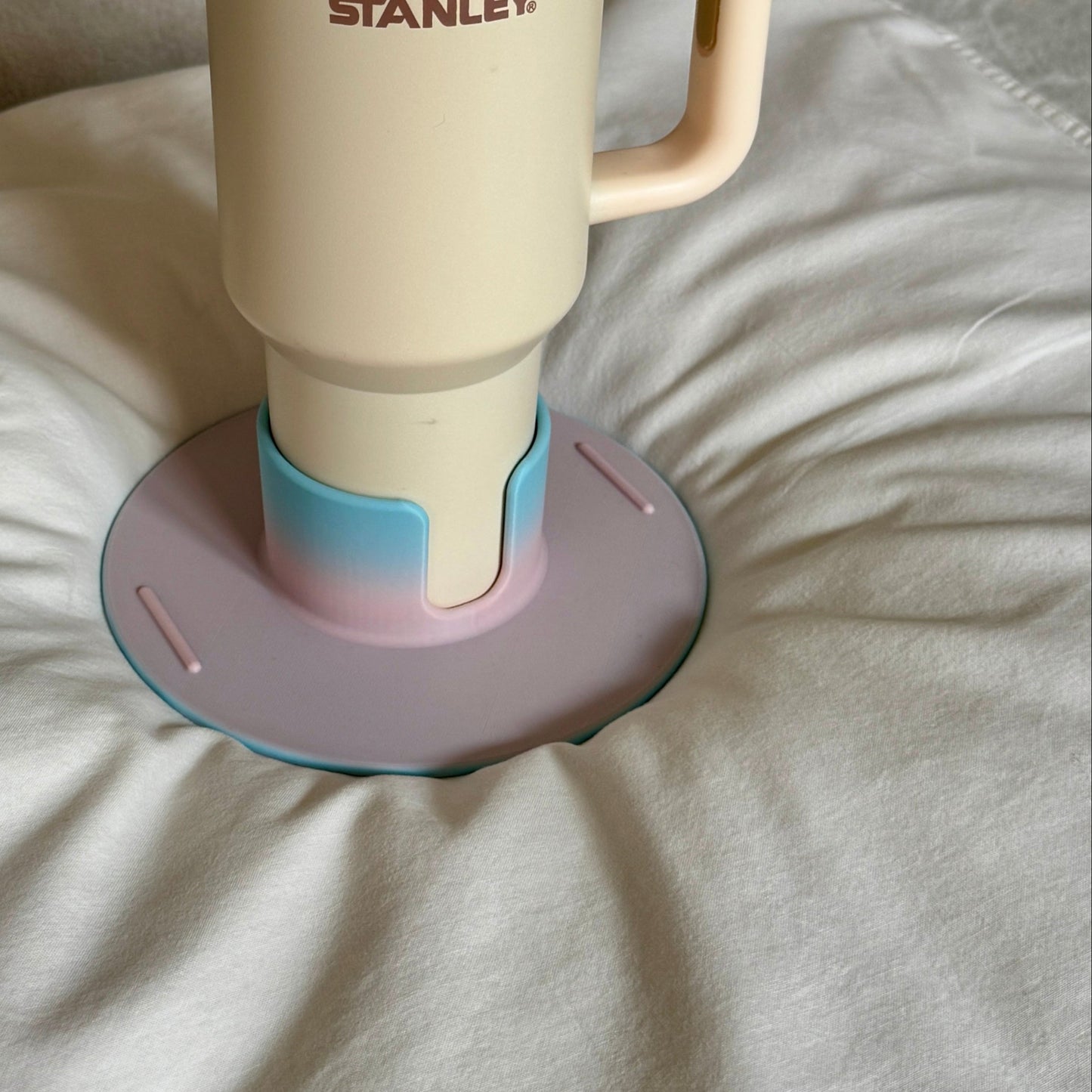 Flonk Becherhalter in Zuckerwatte Rosa-Blau mit Stanley Cup auf Bett und Sofa