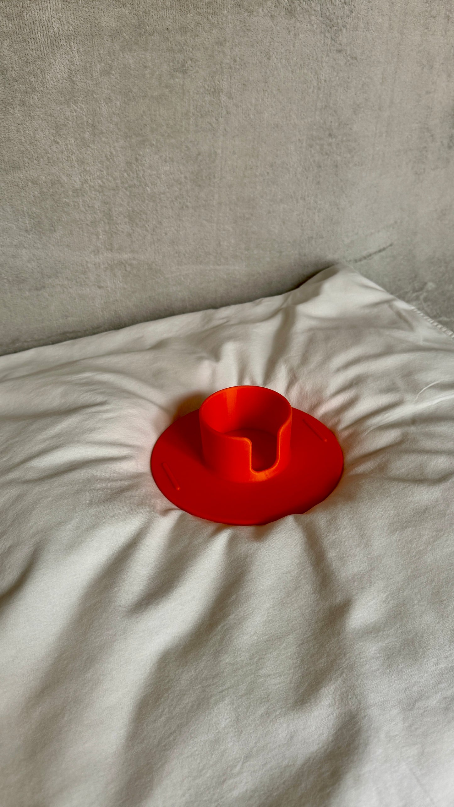 Flonk Becherhalter in Orange mit Stanley Cup auf Bett und Sofa