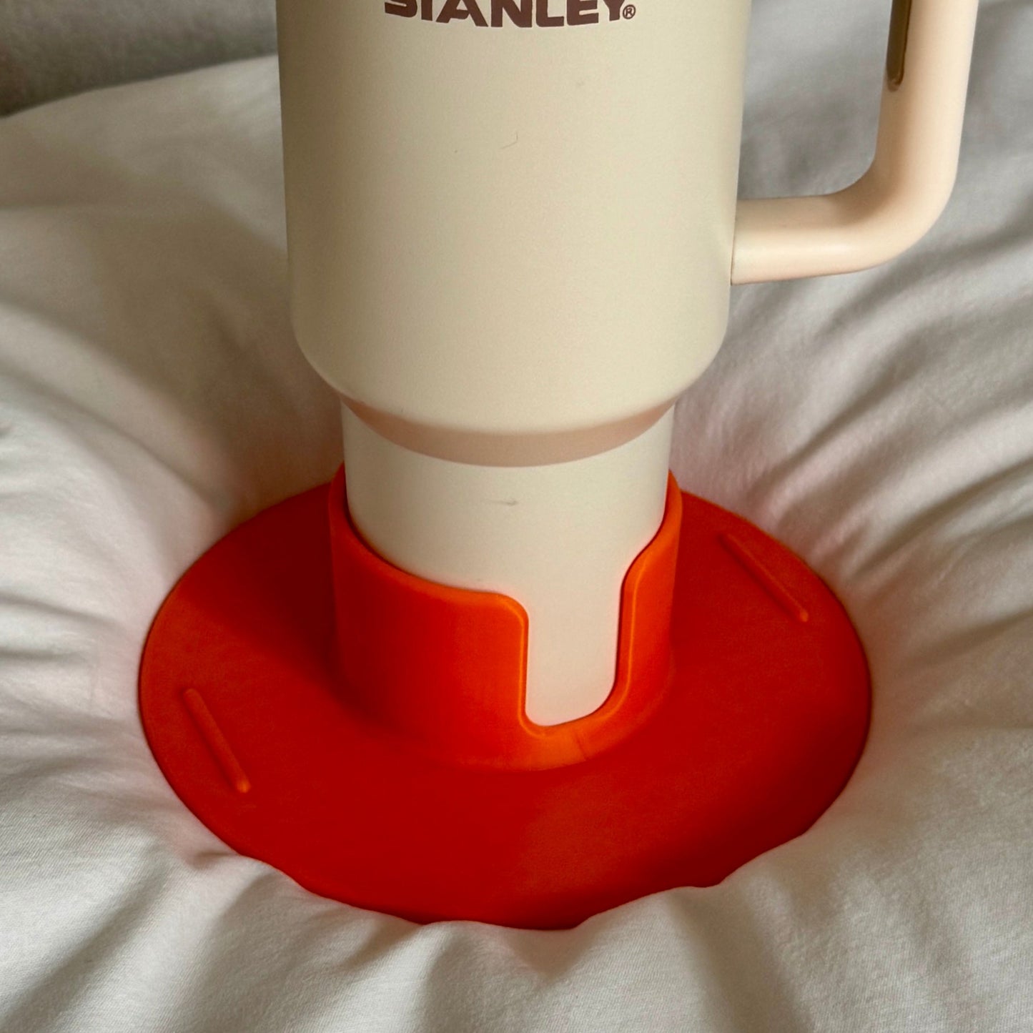 Flonk Becherhalter in Orange mit 40-oz-Stanley Cup auf Bett und Sofa