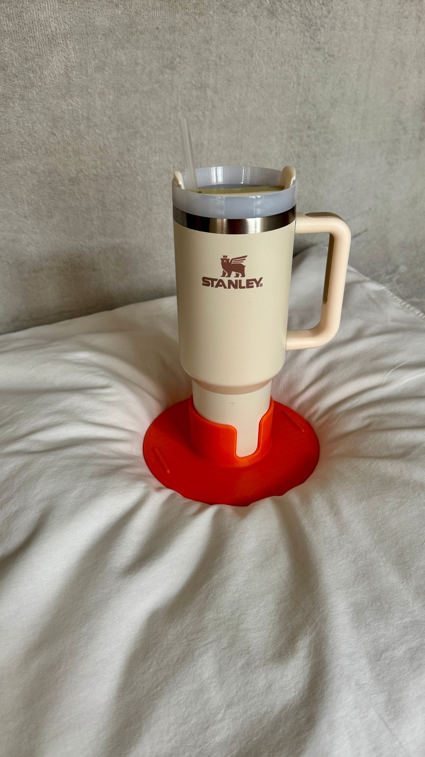 Flonk Becherhalter in Orange mit Stanley Cup auf Bett und Sofa