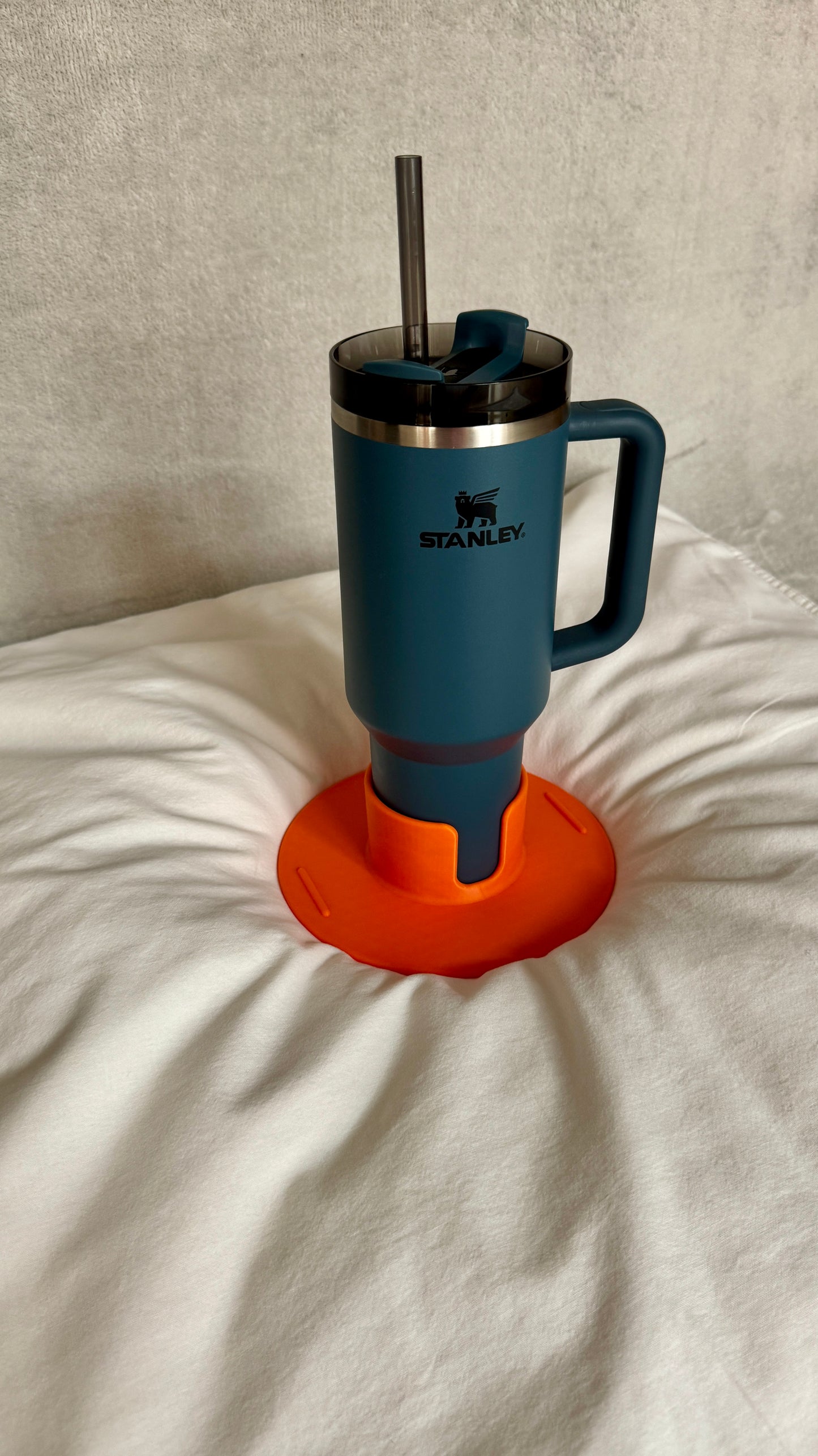 Flonk Becherhalter in Orange mit Stanley Cup auf Bett und Sofa